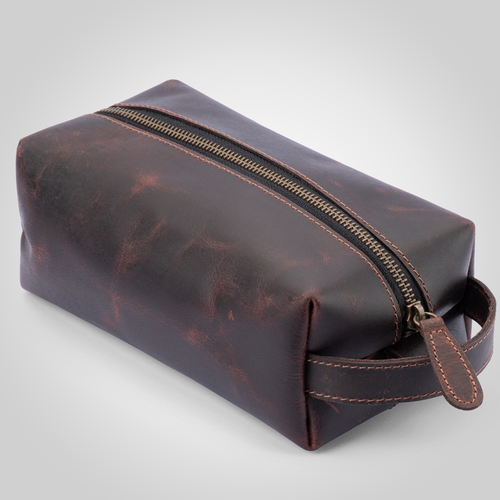 Dark Brown leather toiletry bag with gold zipper on a light gray background